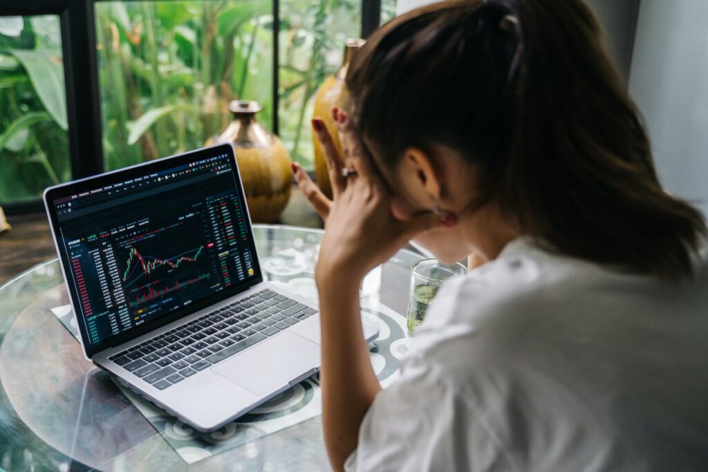 woman looking at cryptocurrency charts on her laptop